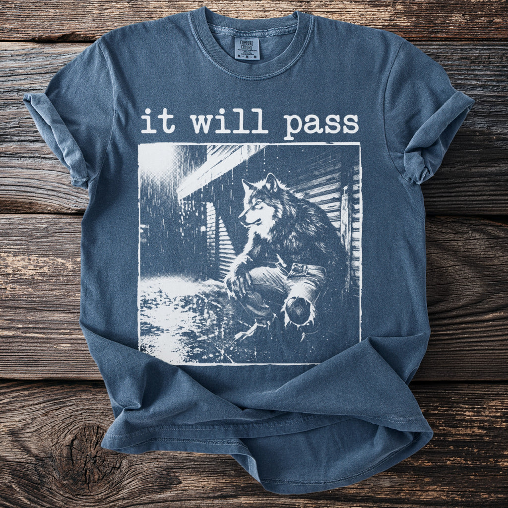 Blue t-shirt with a wolf sitting in the rain, text "it will pass" above.