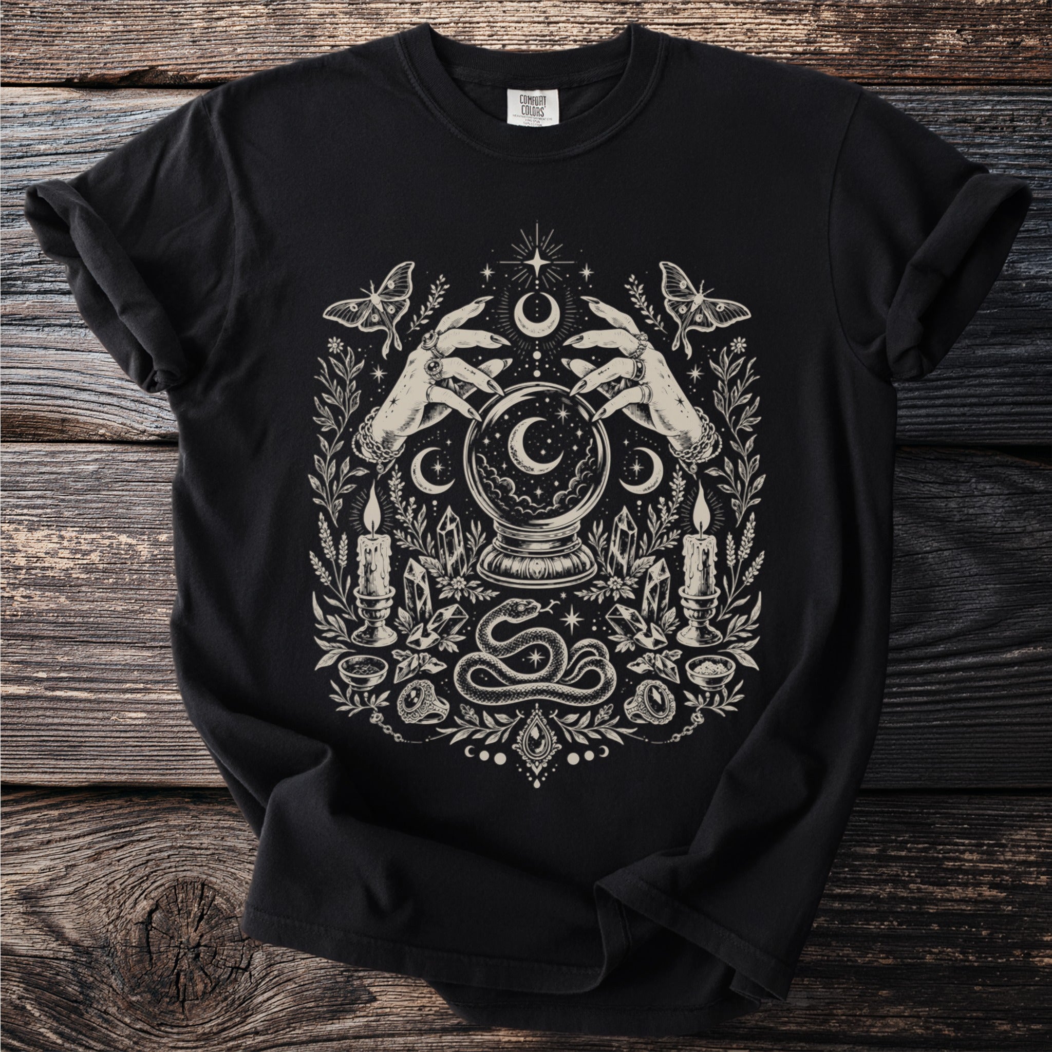 Black t-shirt with hands, crystal ball, snake, moths, candles, and moon graphic.