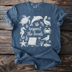 Blue t-shirt with white sea creatures and text "respect the locals".