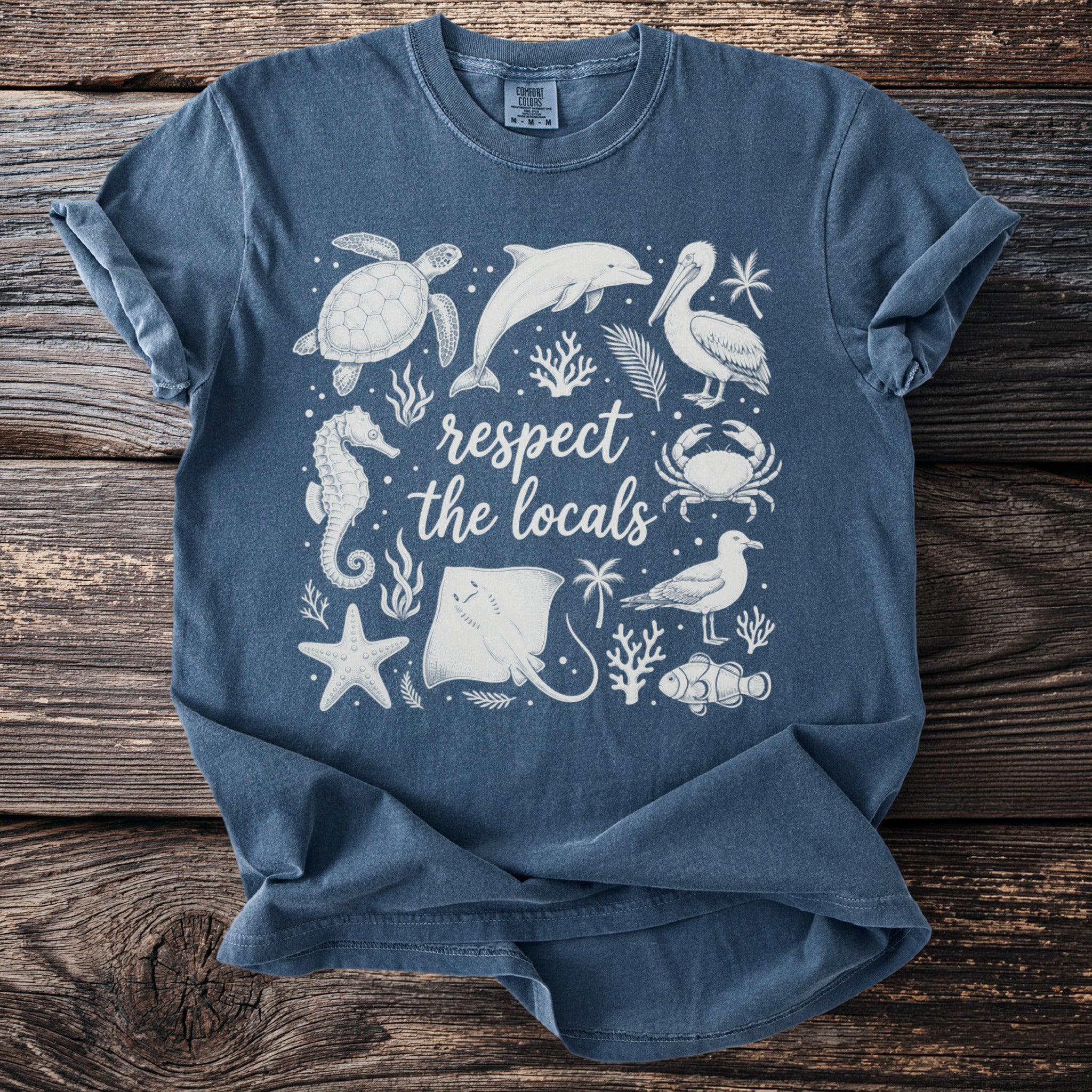 Blue t-shirt with white sea creatures and text "respect the locals".