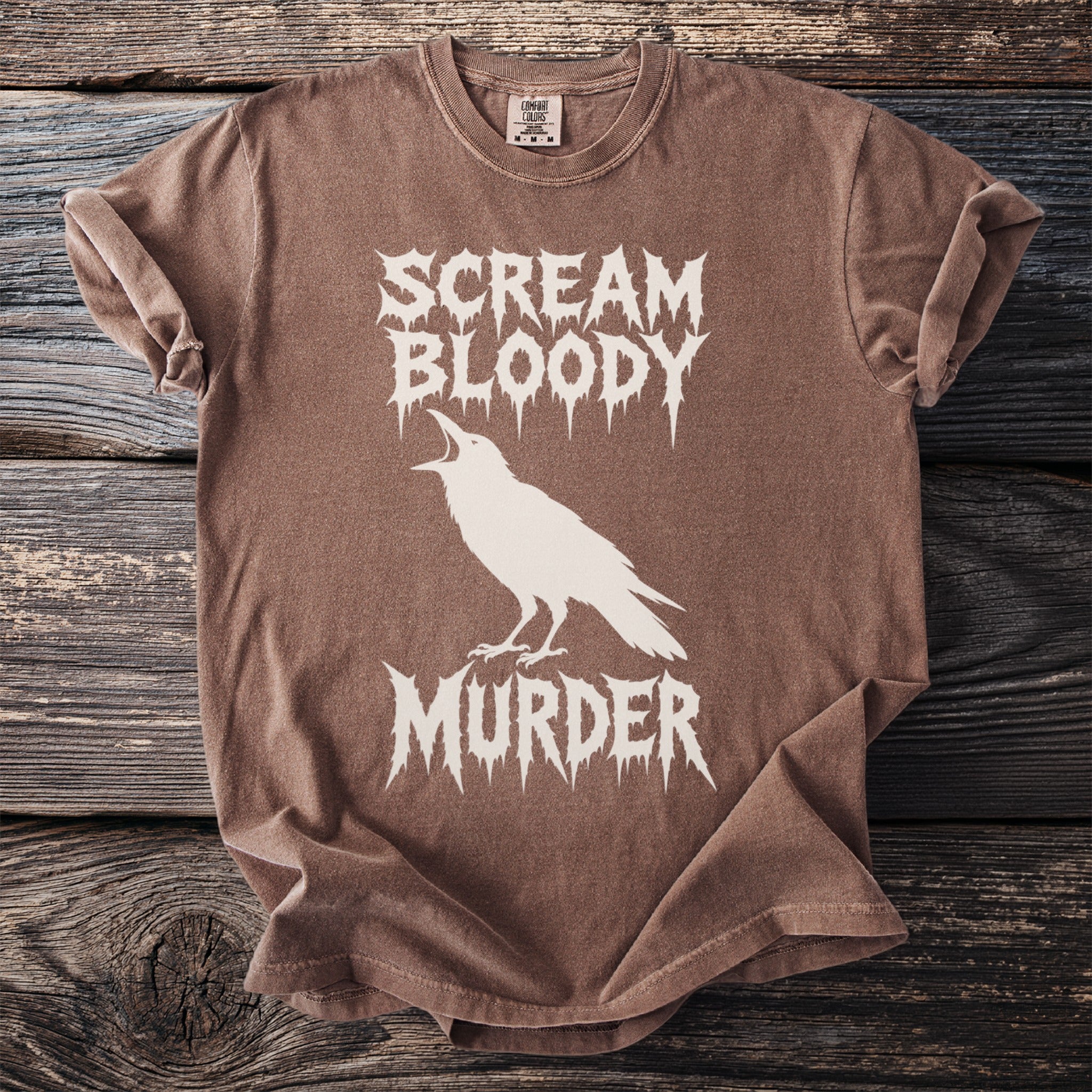 Brown t-shirt with white crow and "Scream Bloody Murder" text.
