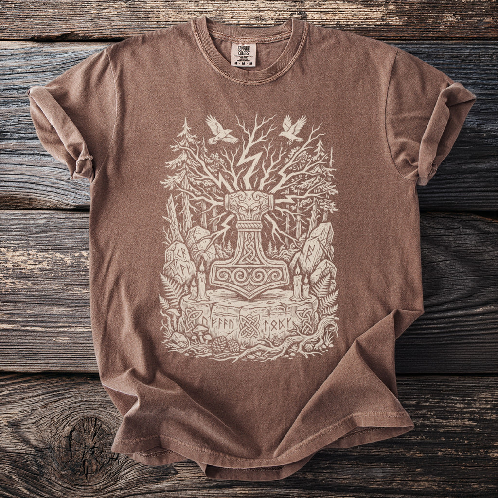 Brown t-shirt with a cream linocut style print of Thor's hammer, Yggdrasil, and Norse runes.