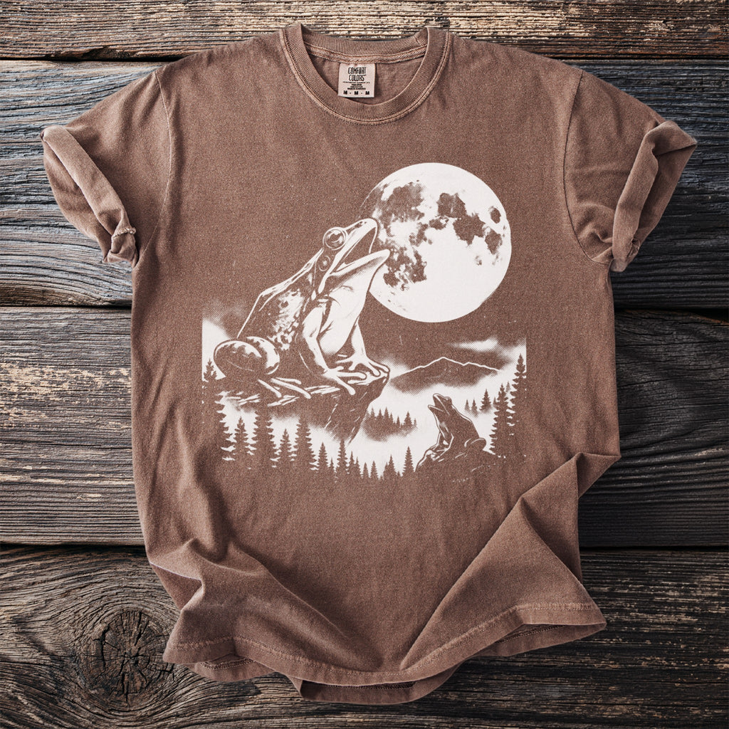 Brown t-shirt with a white graphic of two frogs and a full moon.