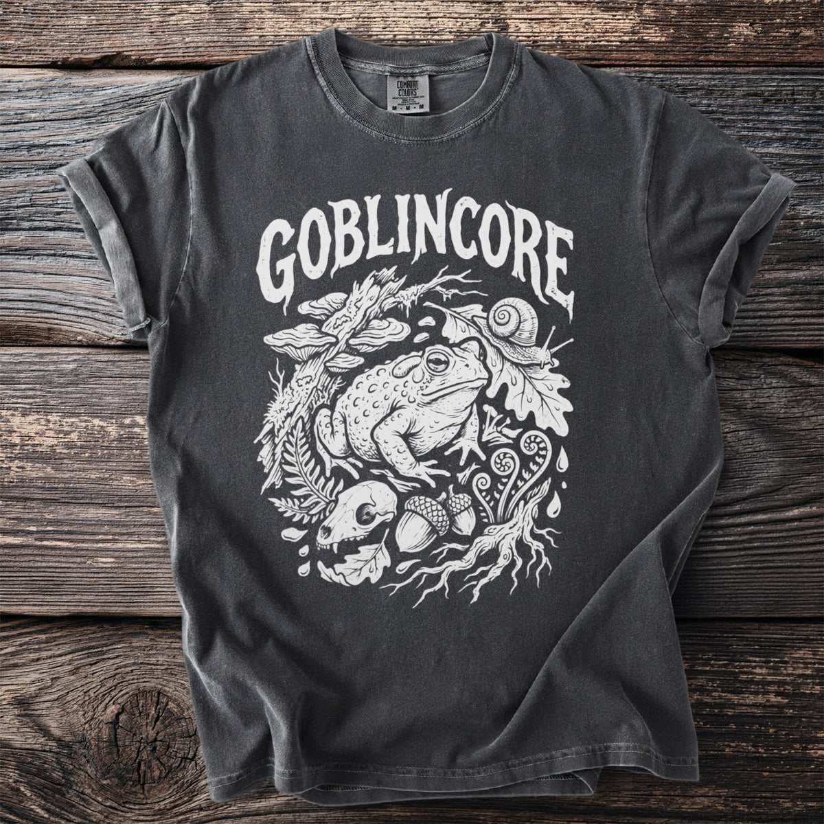 Dark gray t-shirt with white "Goblinore" text and forest creature graphic.