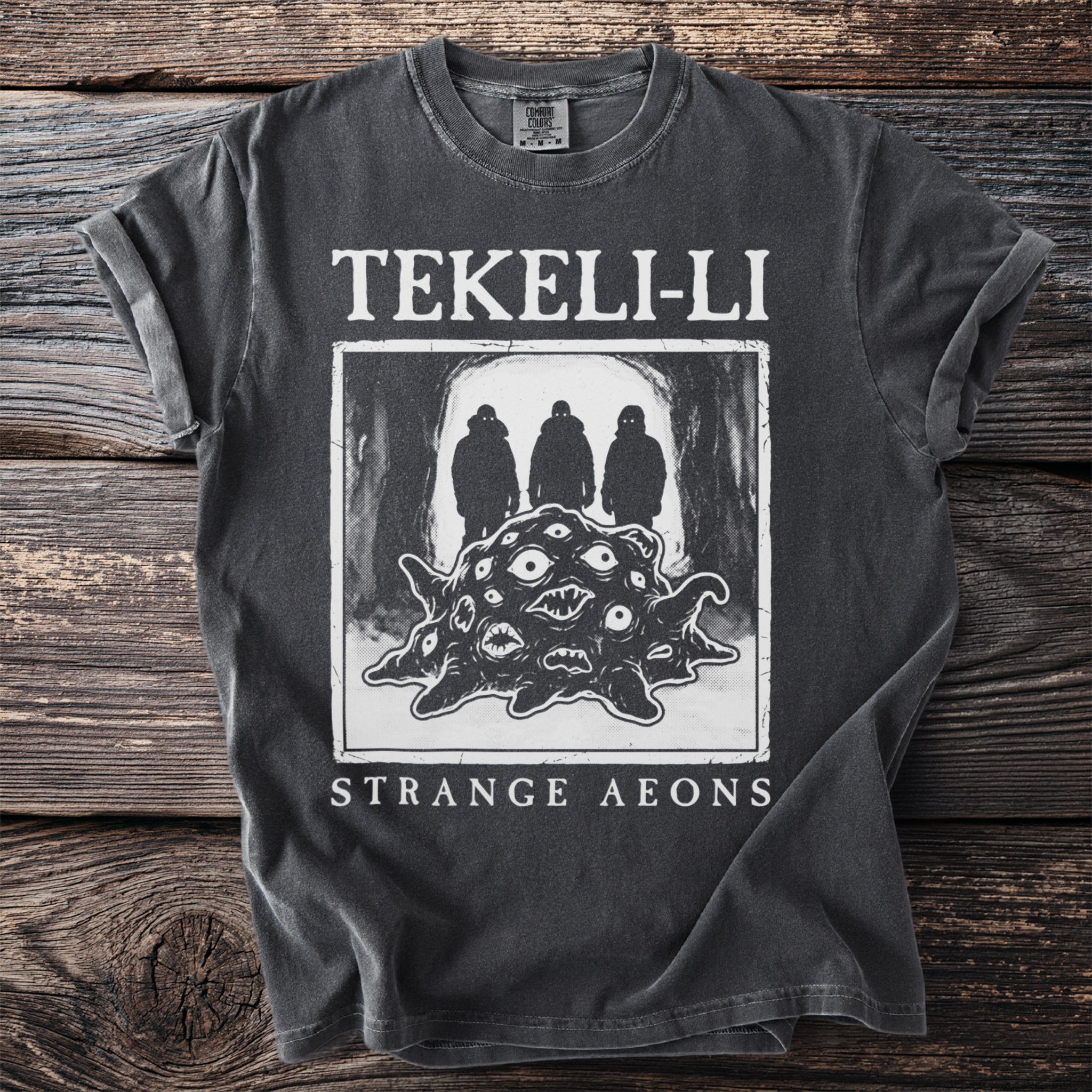 Dark gray t-shirt with "Tekeli-Li Strange Aeons" and a creature with many eyes.