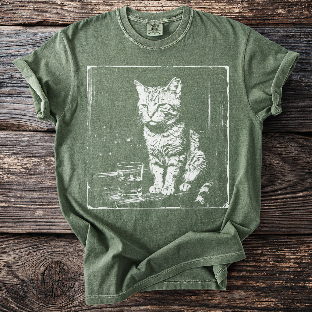 Green t-shirt with white distressed print of a cat and a glass of liquid.