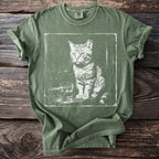 Green t-shirt with white distressed print of a cat and a glass of liquid.