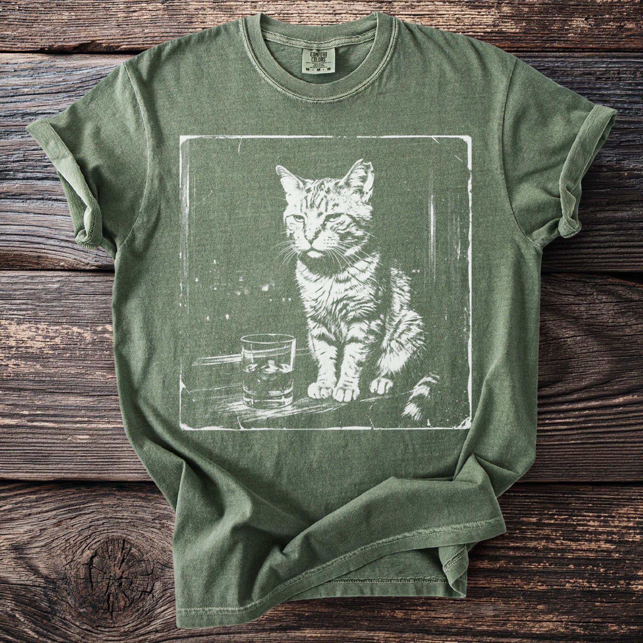 Green t-shirt with white distressed print of a cat and a glass of liquid.
