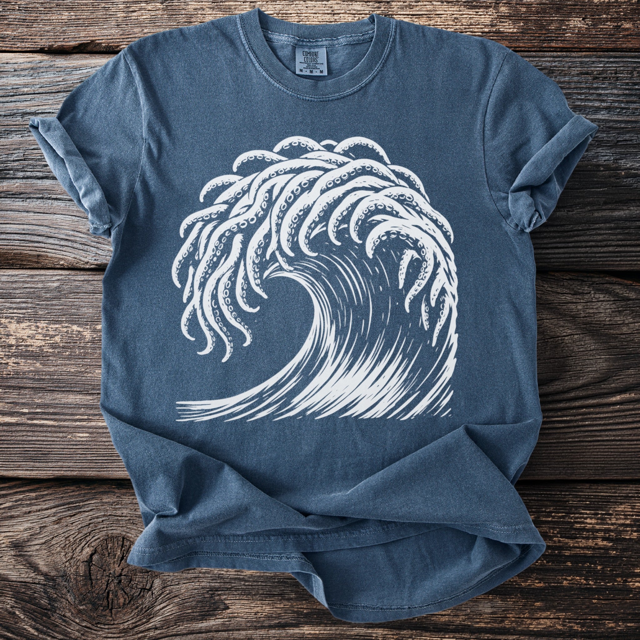 Blue t-shirt with white graphic of octopus tentacles forming a wave.