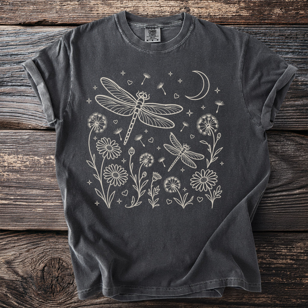Dark grey t-shirt with cream line art of dragonflies, flowers, a moon, and stars.