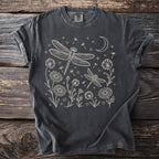 Dark grey t-shirt with cream line art of dragonflies, flowers, a moon, and stars.