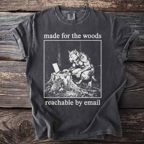 Dark grey t-shirt with a graphic of a werewolf using a laptop on a tree stump, text "made for the woods reachable by email".