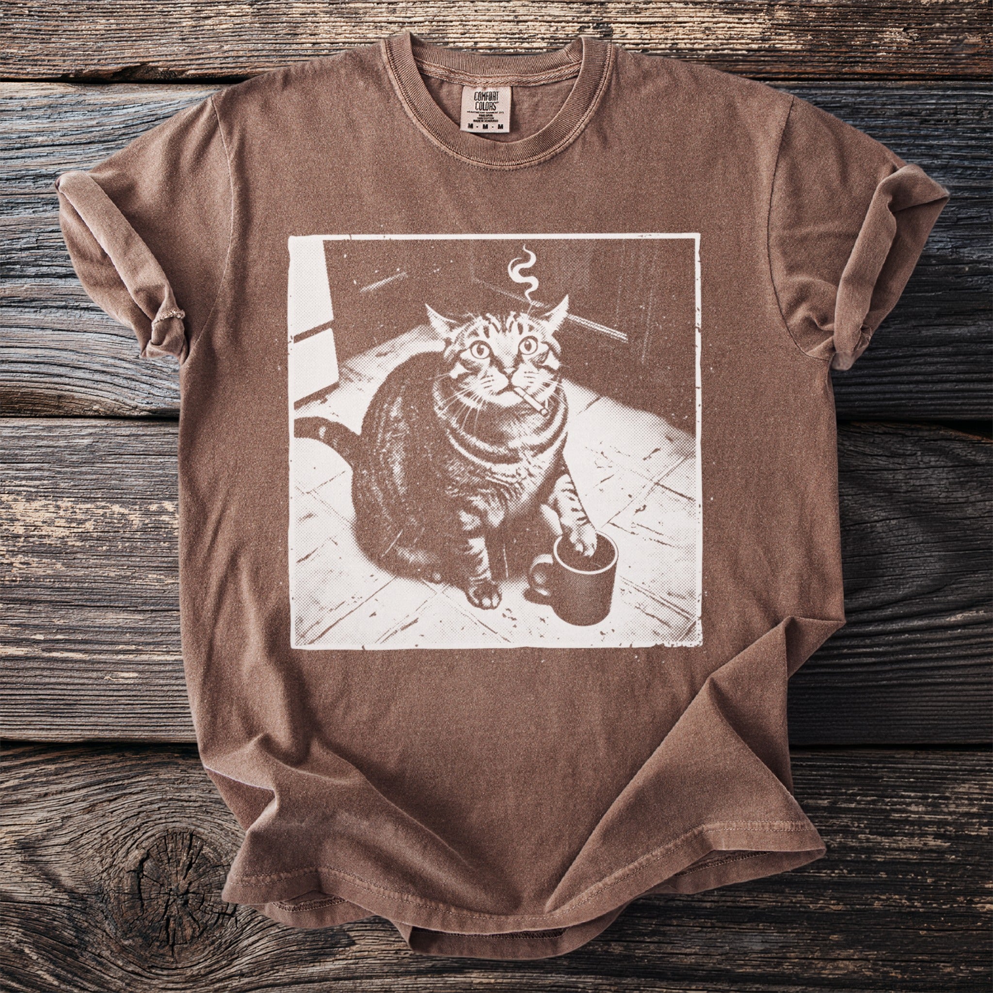 Brown t-shirt with graphic of a cat smoking a cigarette and holding a coffee mug.