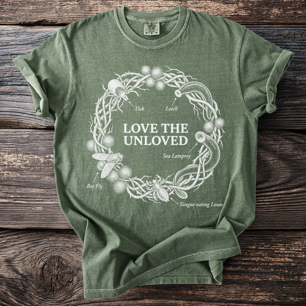 Green t-shirt with white graphic of a thorny wreath containing insects and "Love the Unloved" text.