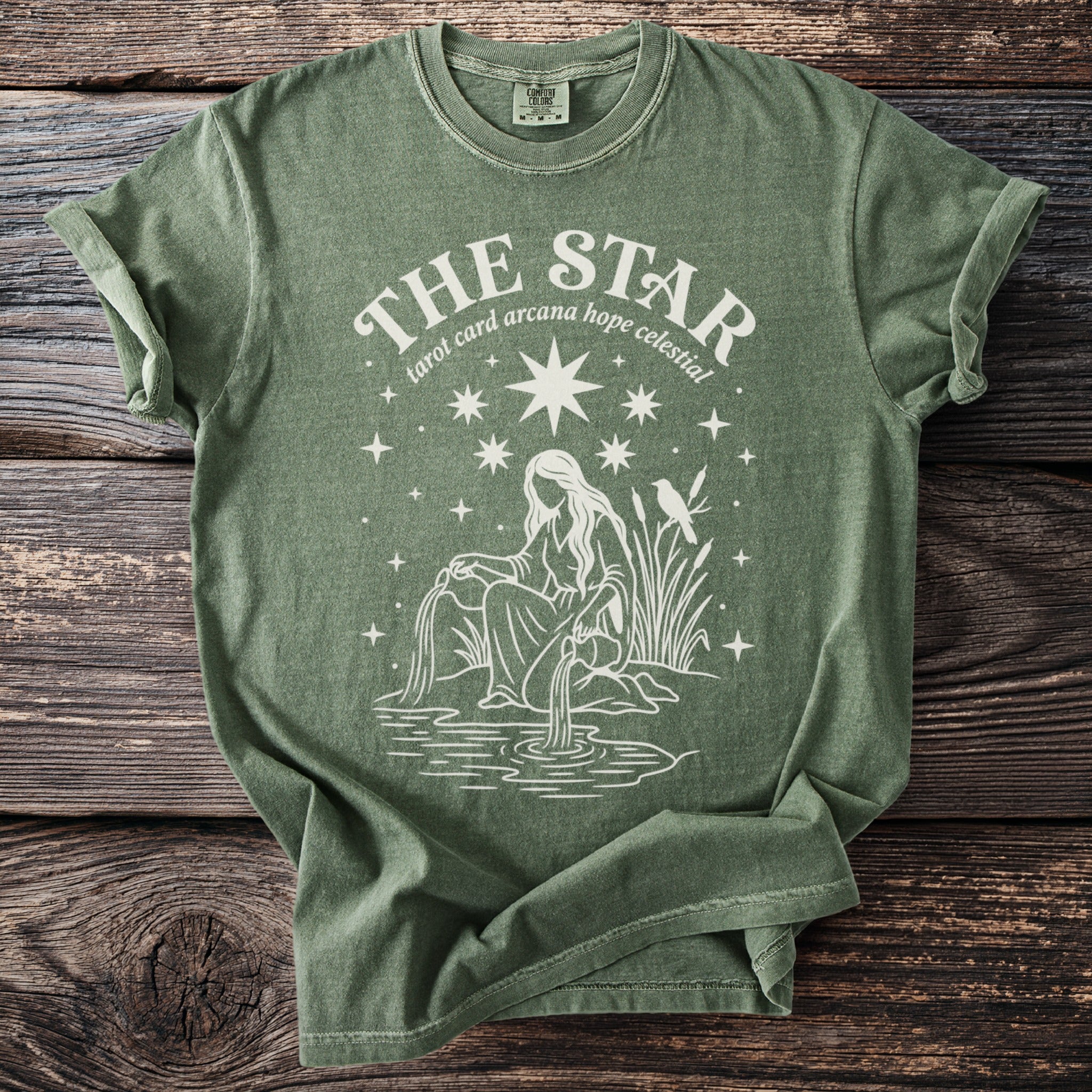 Green t-shirt with "The Star tarot card arcana hope celestial" text and celestial illustration.