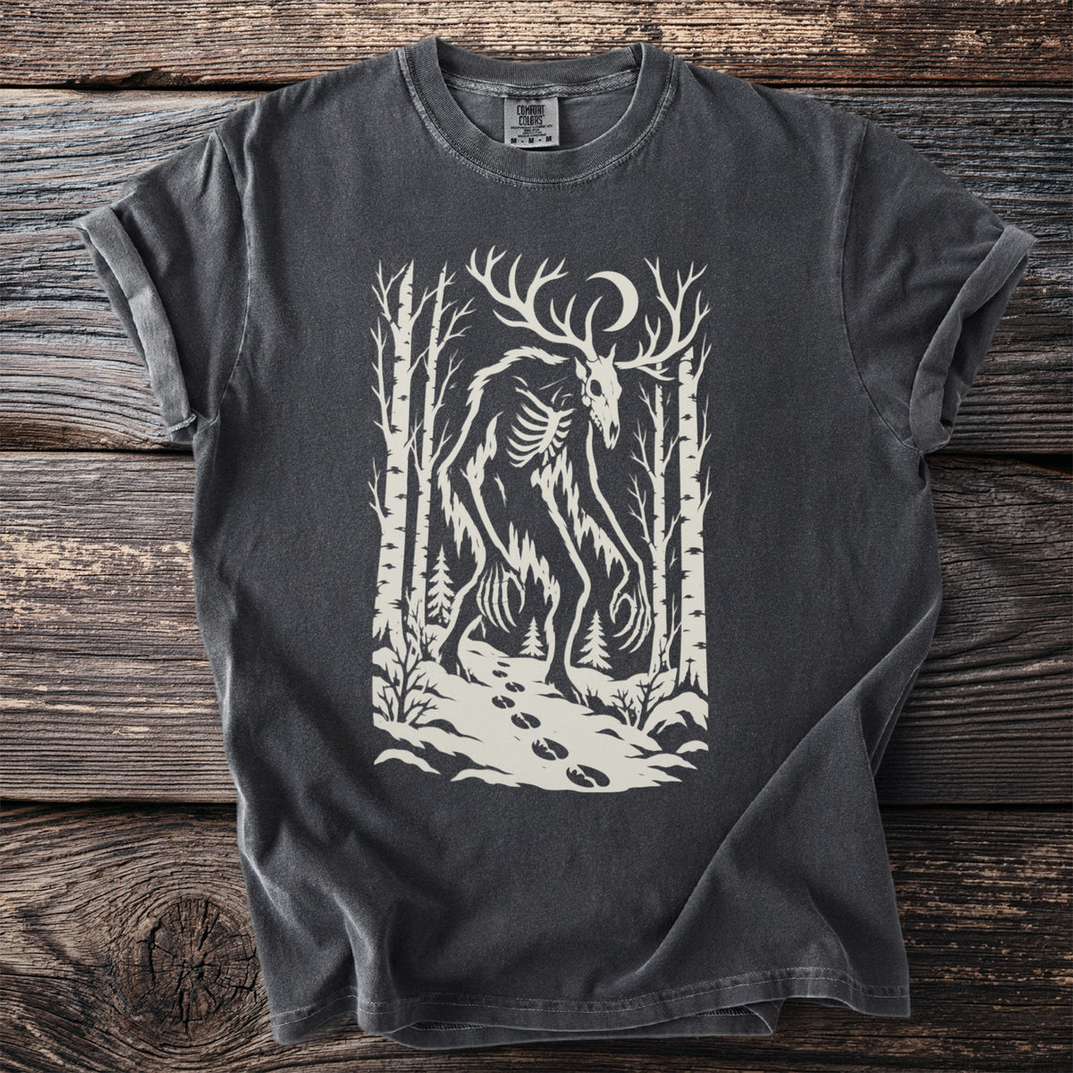 Dark grey t-shirt with a cream-colored graphic of a skeletal creature with antlers in a forest.
