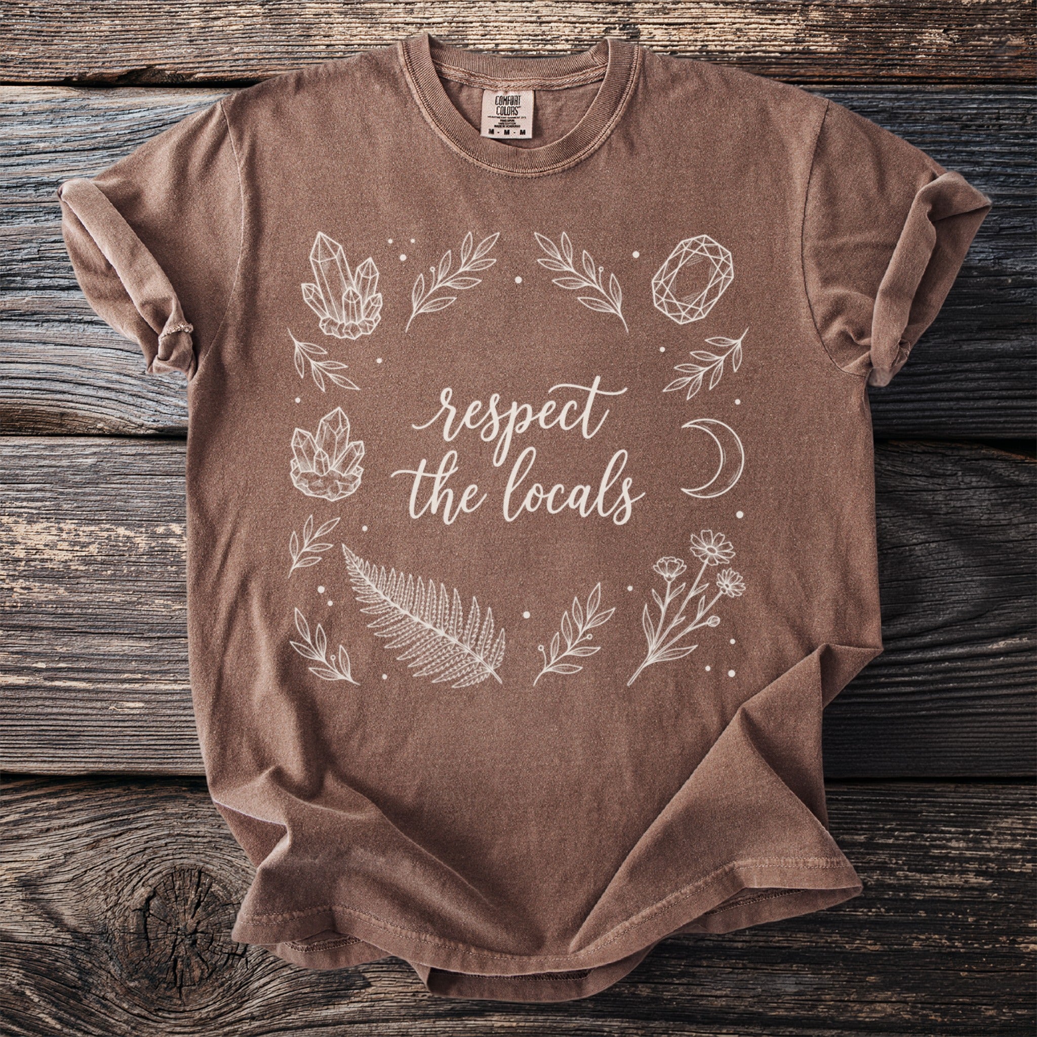 Brown t-shirt with "respect the locals" text and botanical illustrations.