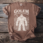 Brown t-shirt with white graphic of a Golem, moon, and city buildings