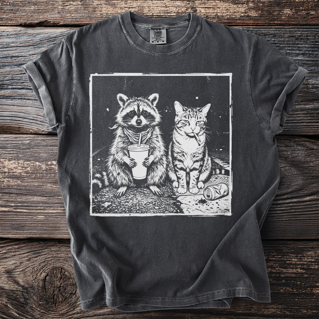 Dark t-shirt with a black and white graphic of a raccoon holding a drink and a cat smoking