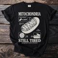 Black t-shirt with "Mitochondria" graphic and "Still Tired" text.