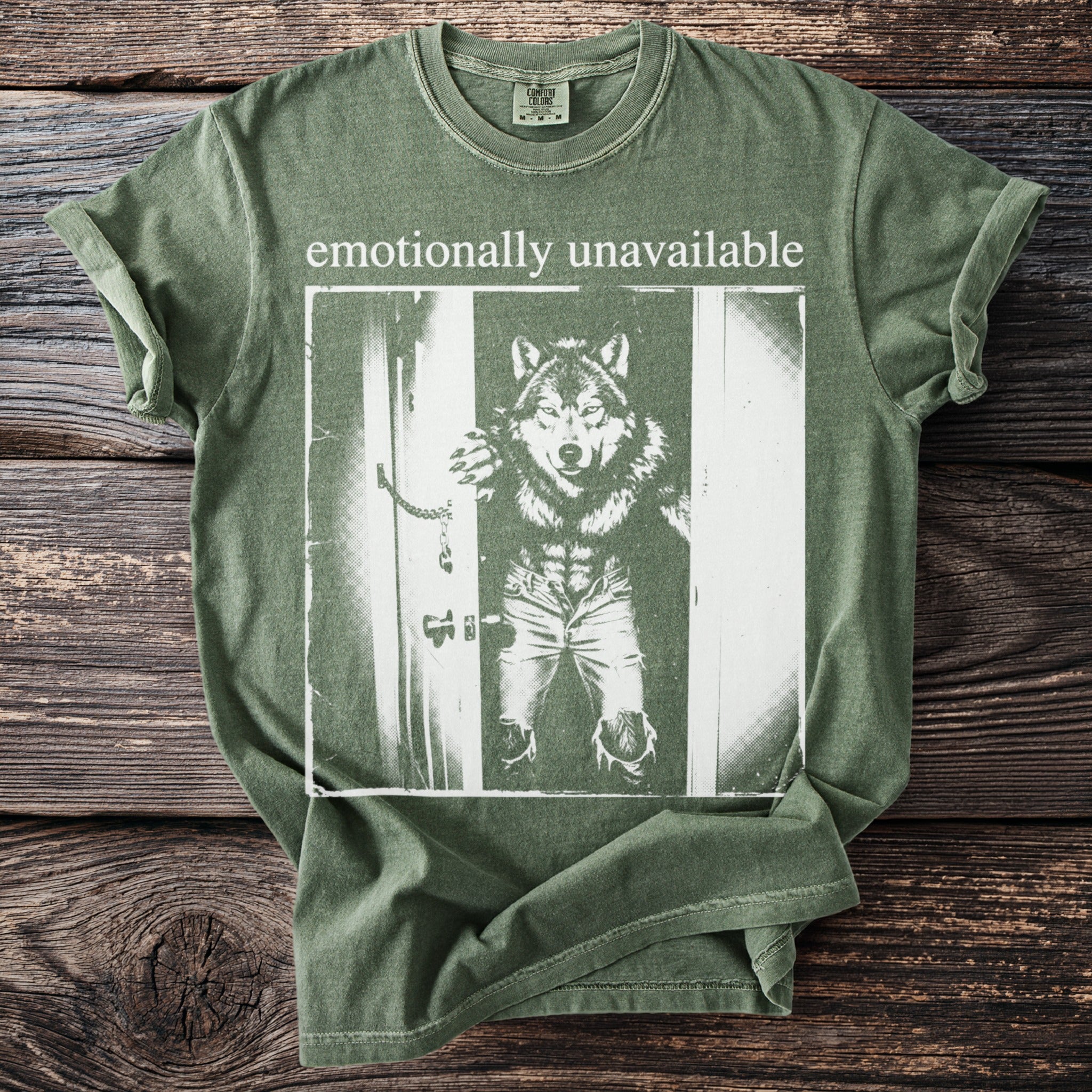 Green t-shirt with "emotionally unavailable" text and a wolf in ripped jeans.
