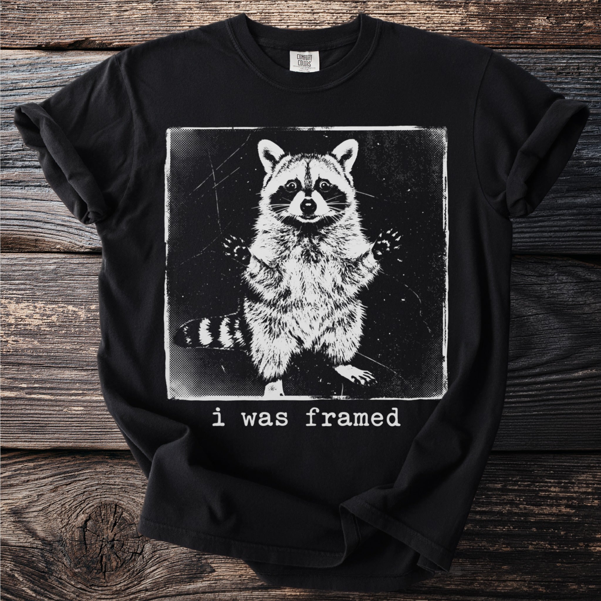 Black t-shirt with a distressed graphic of a raccoon and the text "i was framed".