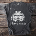 Dark t-shirt with a black and white close-up of a frog and the text "i have warts."