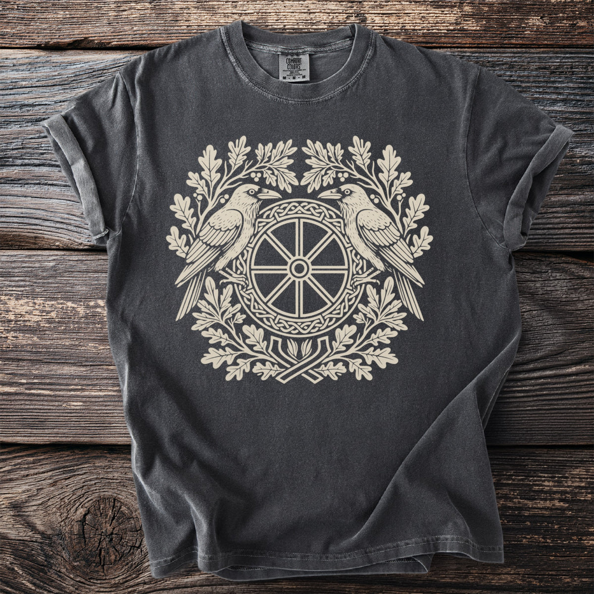 Dark grey t-shirt with a cream-colored raven and wheel design surrounded by oak leaves.