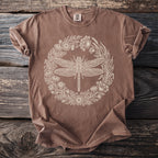 Brown t-shirt with a white dragonfly and floral wreath graphic and "Comfort Colors" label.