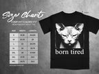 Black t-shirt with a sphynx cat graphic and "born tired" text, displayed with a size chart.