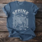 Blue t-shirt with white line art of a sphinx and text "SPHINX GREEK RIDDLE GUARDIAN MYTH".
