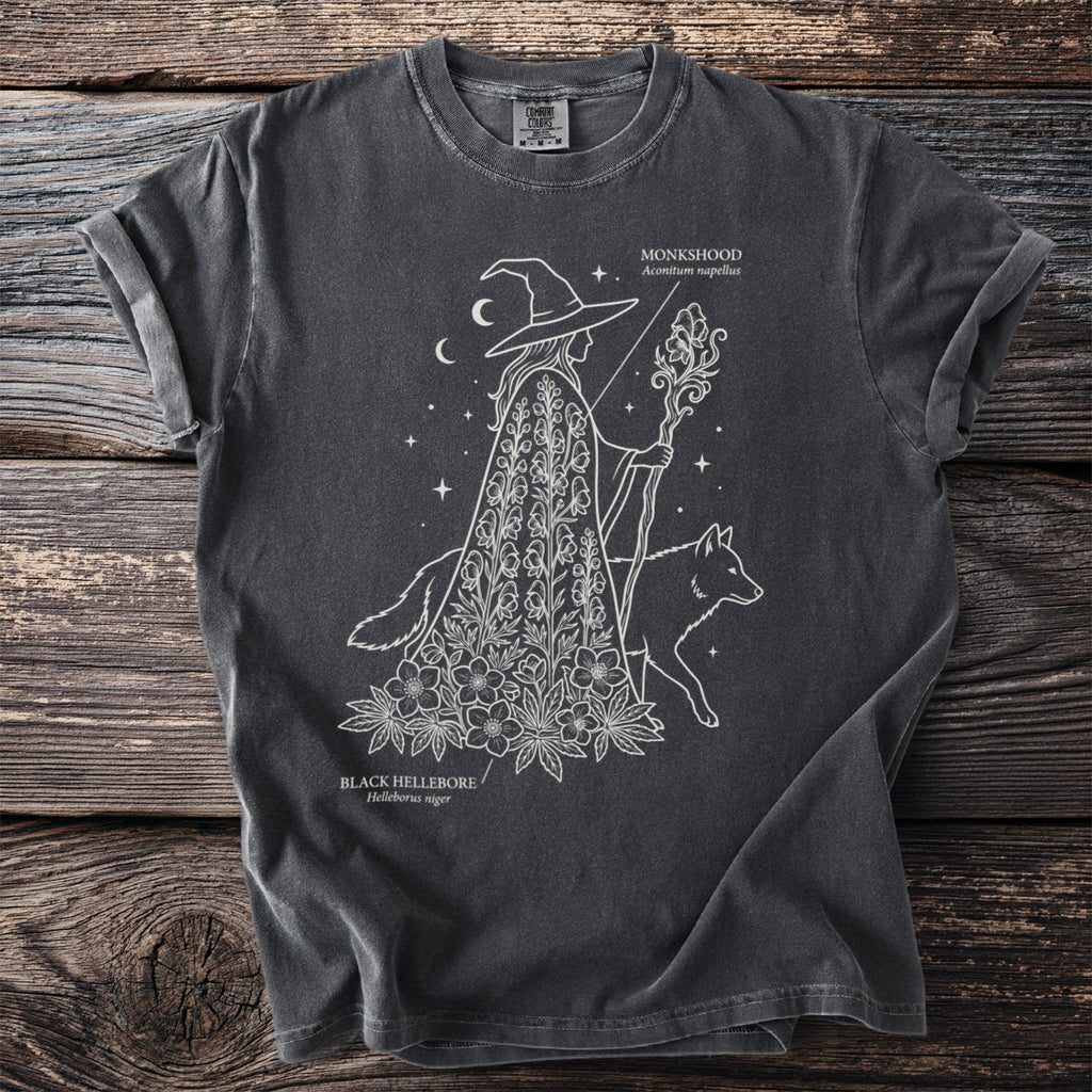 Dark gray t-shirt with white line art of a witch, wolf, monkshood, and black hellebore.