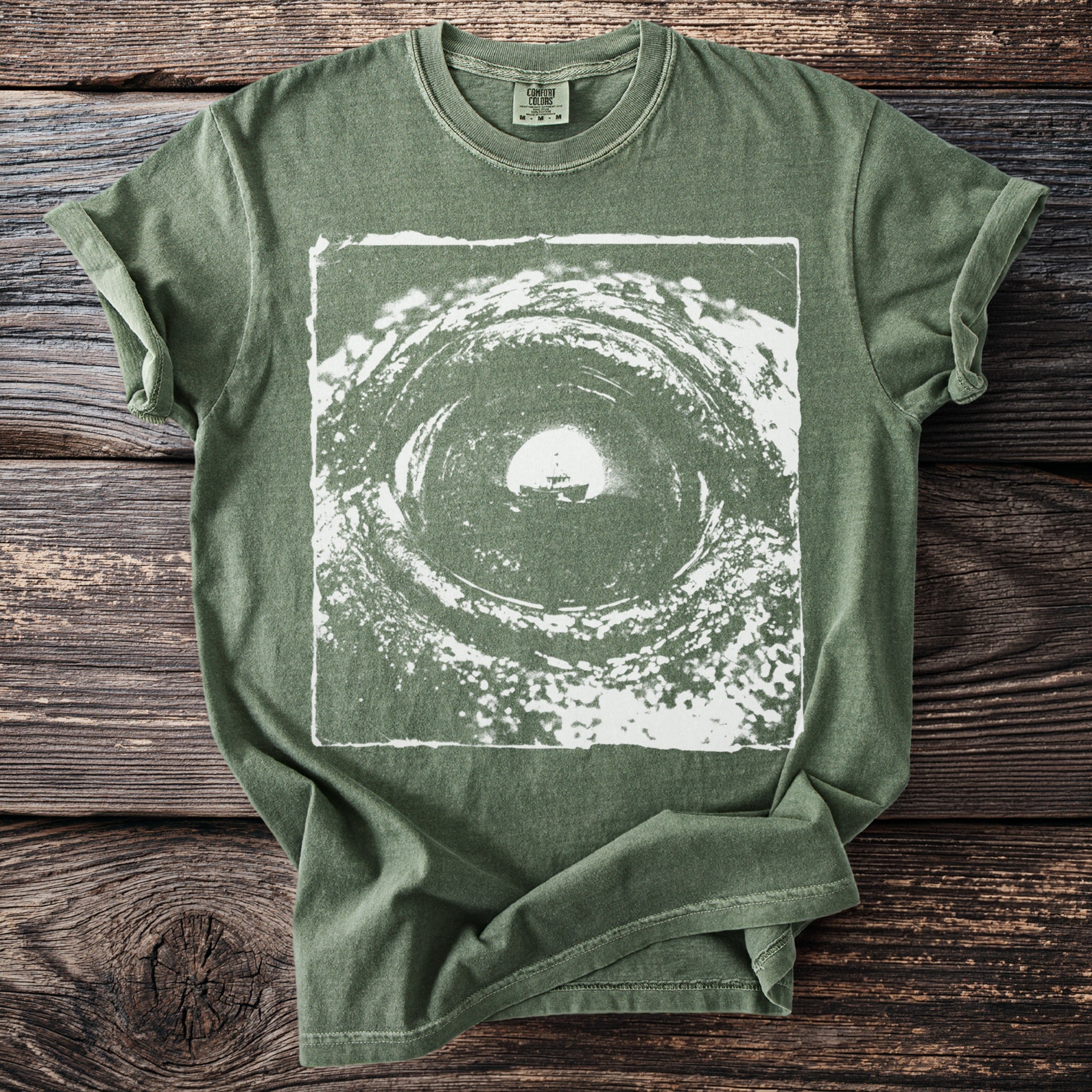 Green t-shirt with a white abstract vortex graphic and a ship.