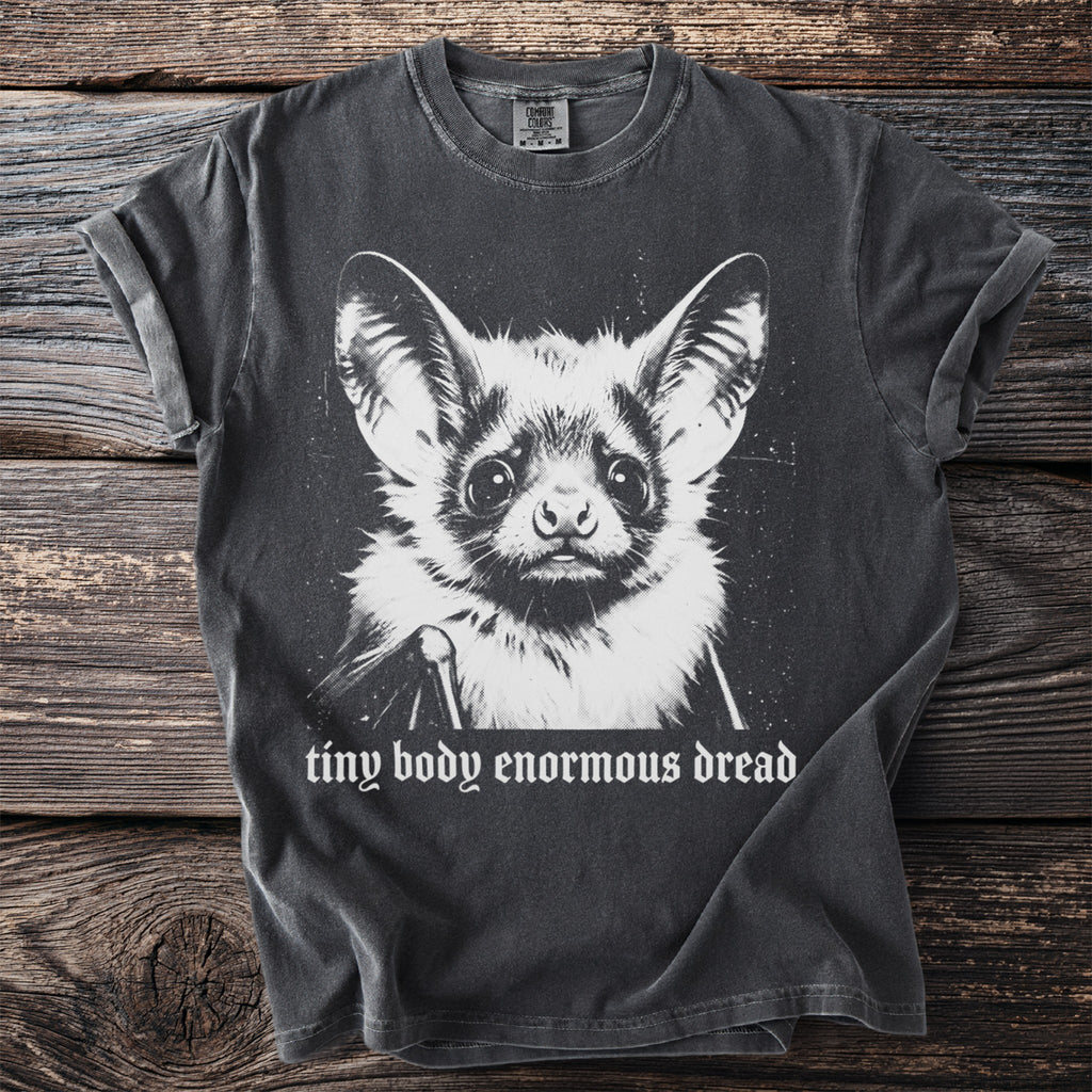 Dark grey t-shirt with a black and white bat graphic and text "tiny body enormous dread".