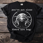 Black t-shirt with white graphic of a beetle and text "you're not alone there are bugs".