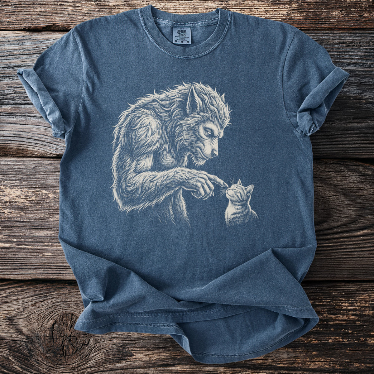 Werewolf gently touching nose of a kitten, on a blue t-shirt.