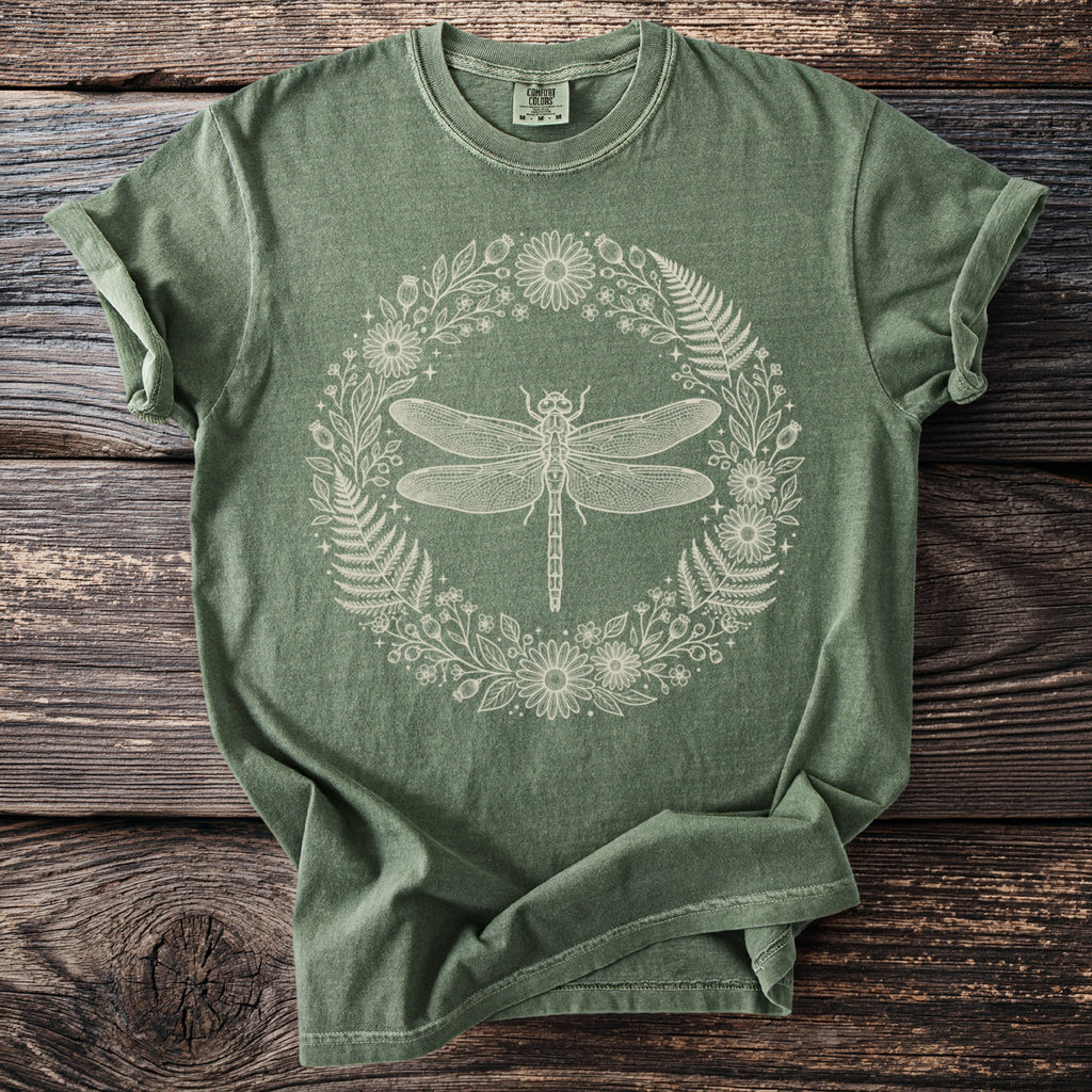 Green t-shirt with cream-colored dragonfly and floral wreath graphic.