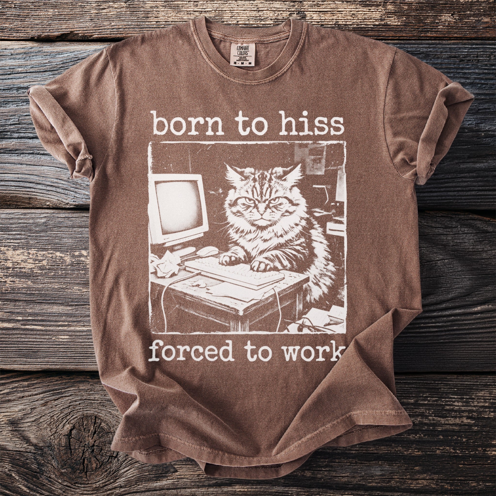 Brown t-shirt with white text "born to hiss forced to work" and a cat at a computer.