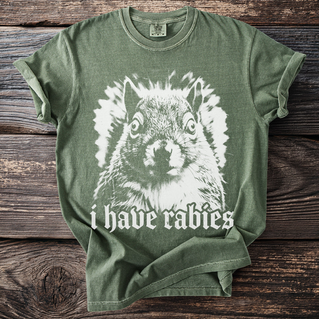 Green t-shirt with a white graphic of a squirrel and "i have rabies" text.