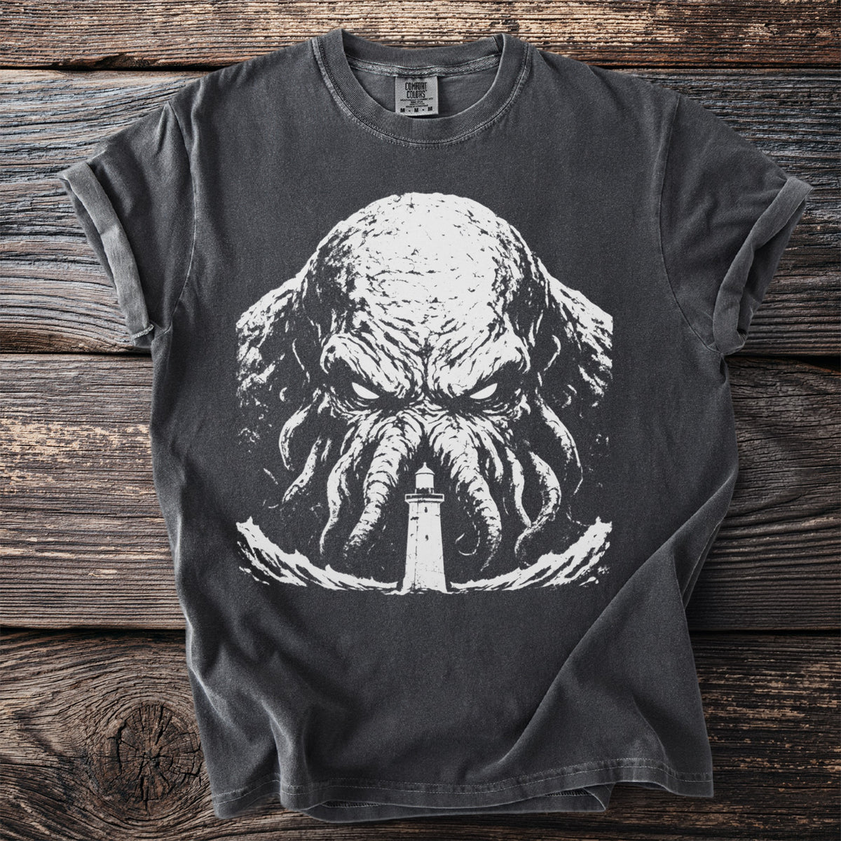 Dark t-shirt with a white graphic of a tentacled creature and a lighthouse.