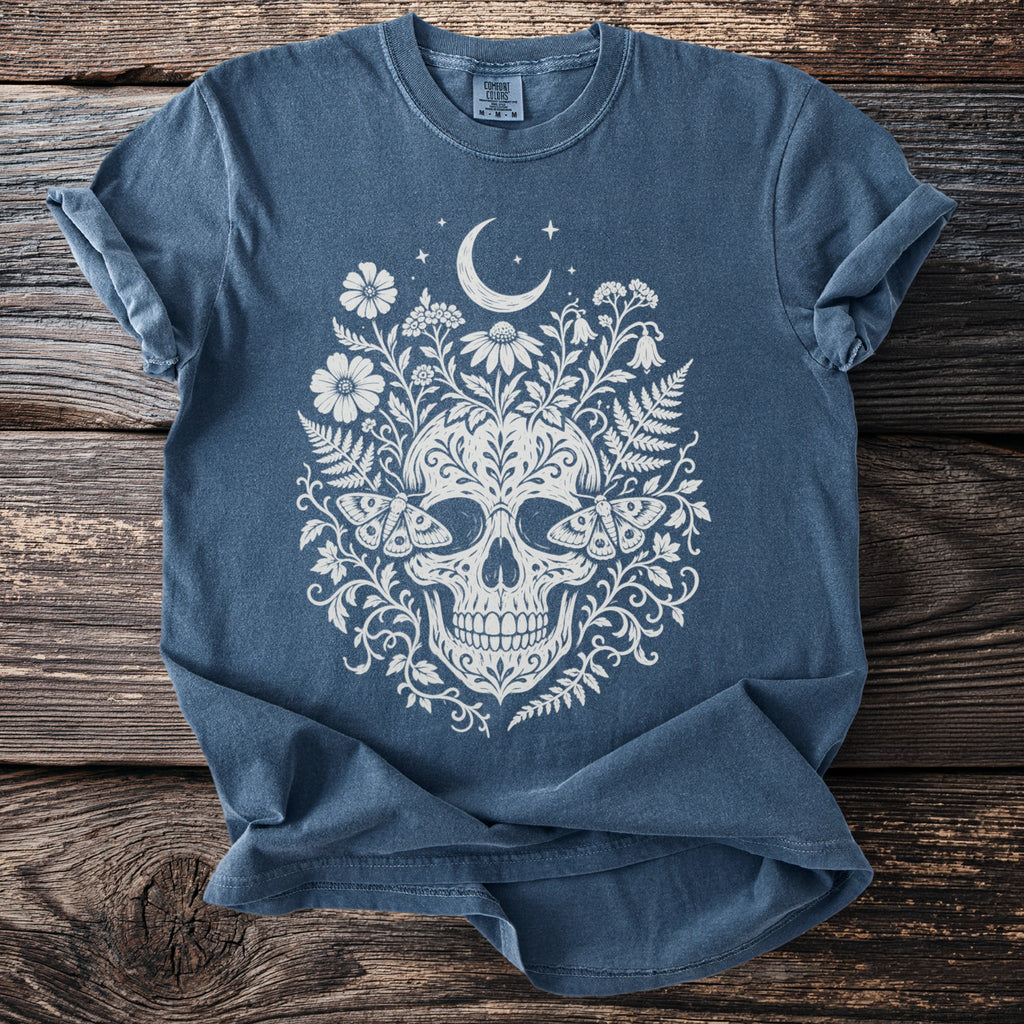 Blue t-shirt with cream skull, floral, moon, and moth graphic.