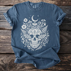 Blue t-shirt with cream skull, floral, moon, and moth graphic.