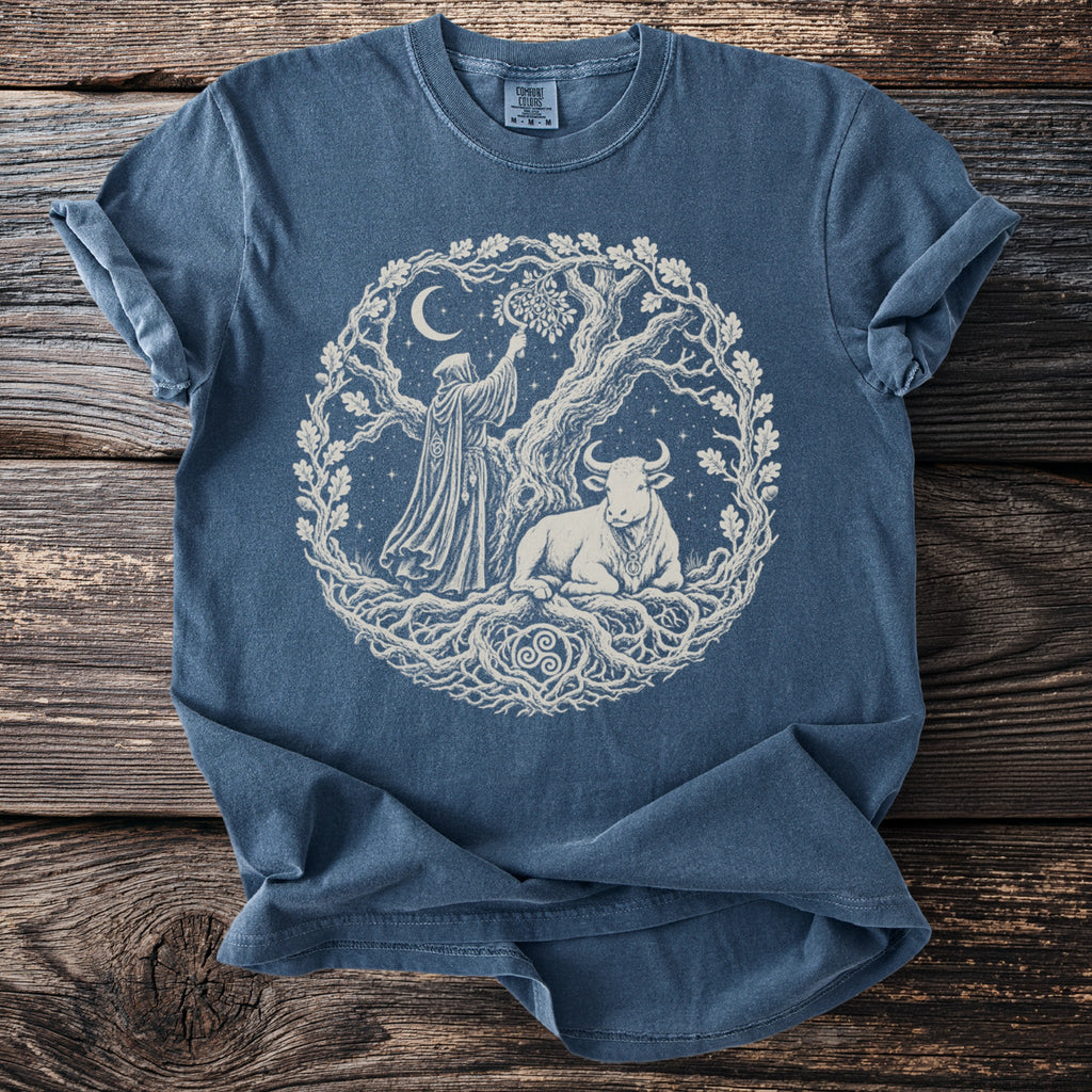 Blue t-shirt with cream circular print of a robed figure, bull, and tree.