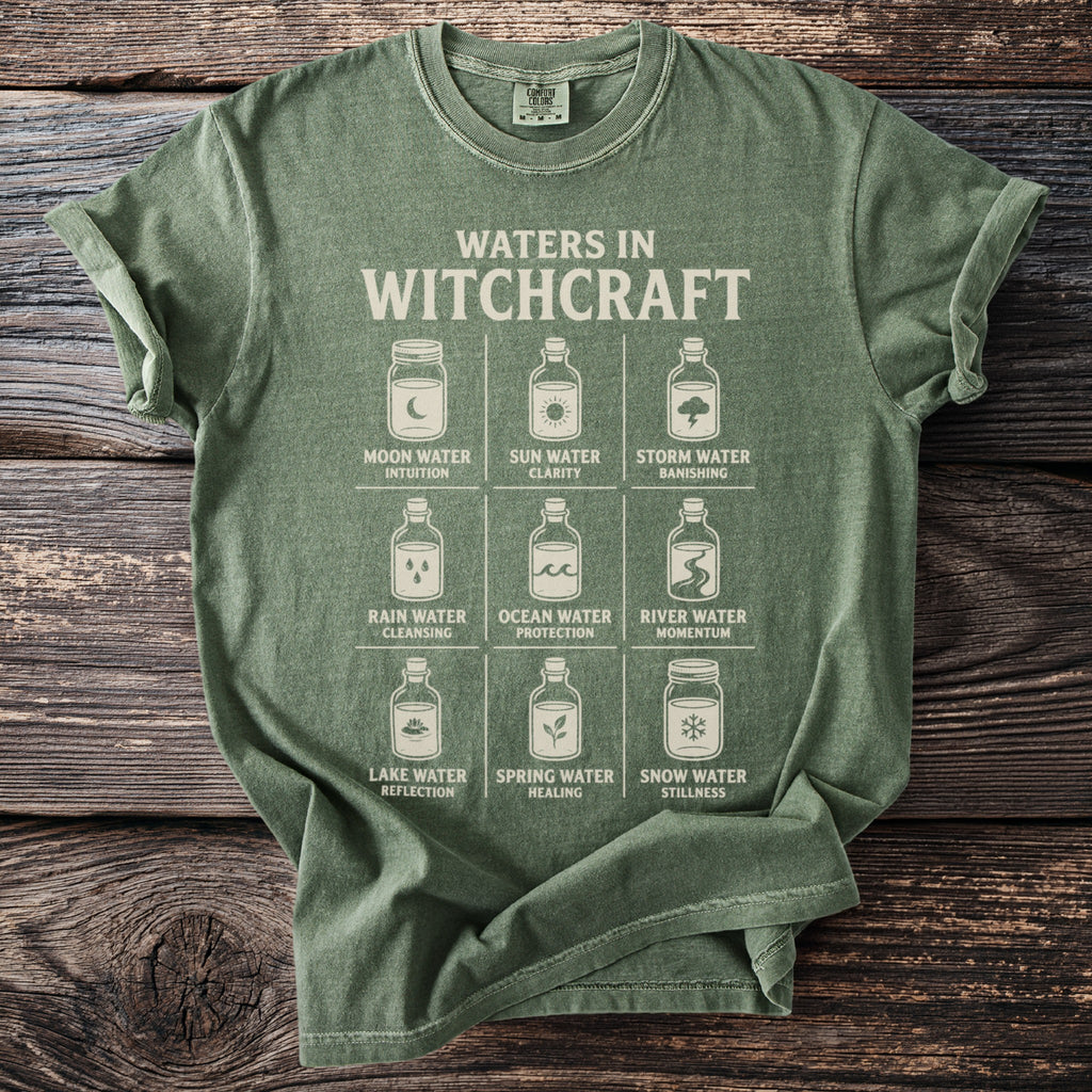 Green t-shirt with "Waters in Witchcraft" and nine labeled jars of water.