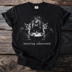 Three cats sit around a table with a candle, text reads "meeting adjourned".