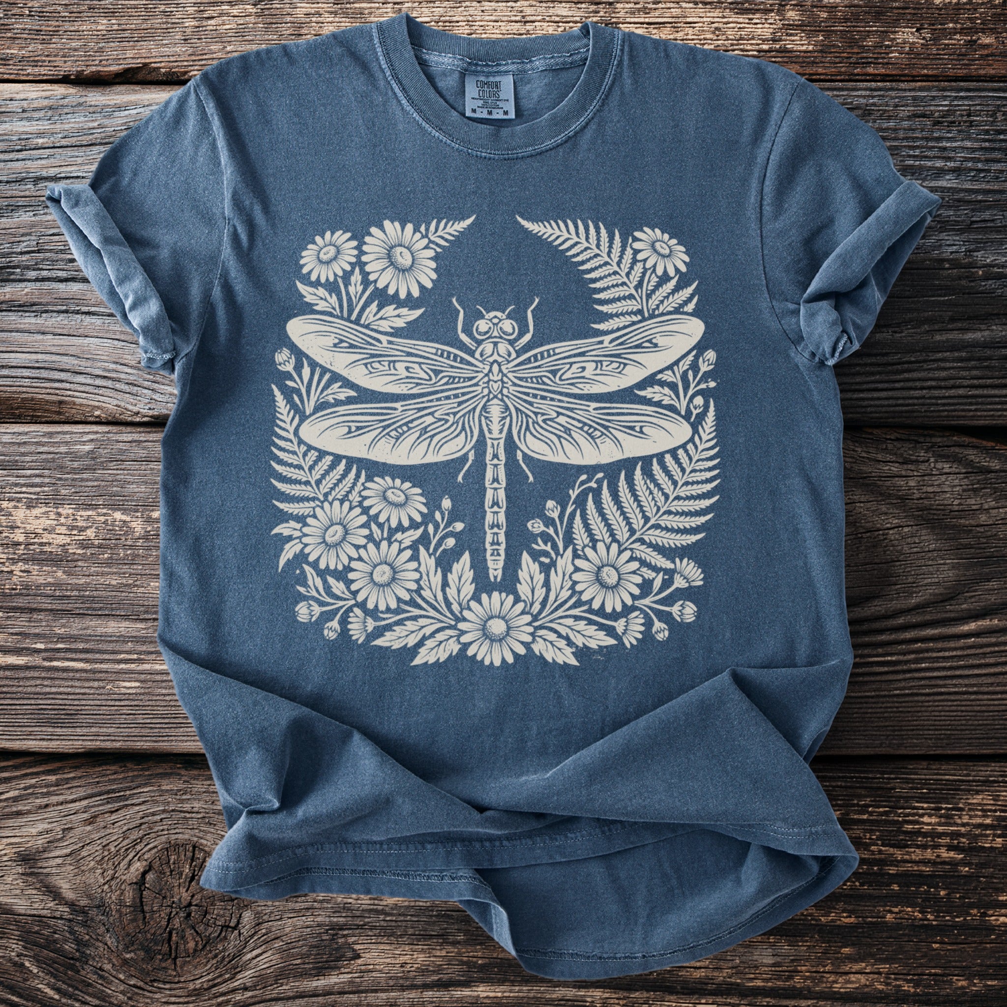 Blue t-shirt with a cream dragonfly and floral design.