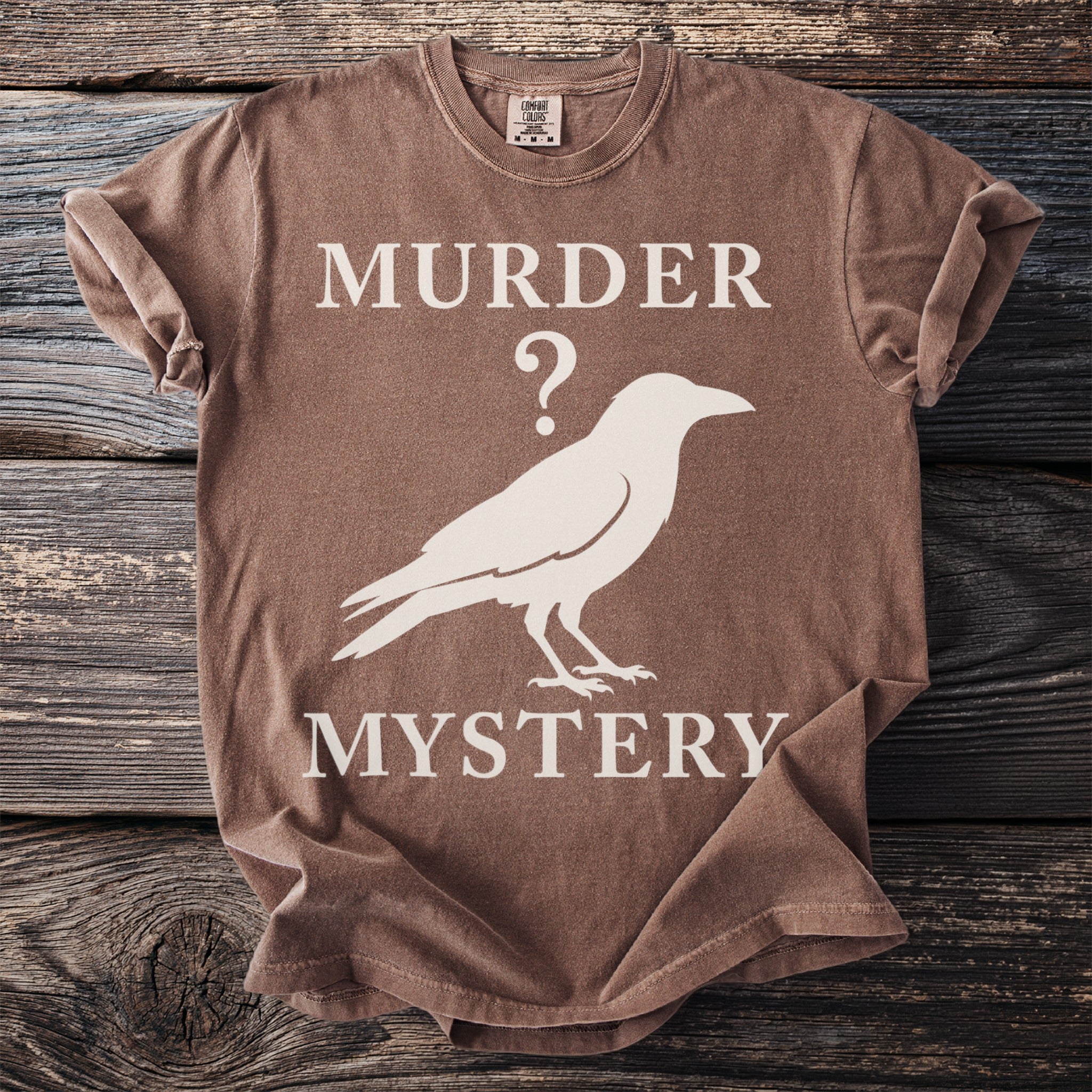 Brown t-shirt with white text "MURDER ?", raven silhouette, and "MYSTERY".