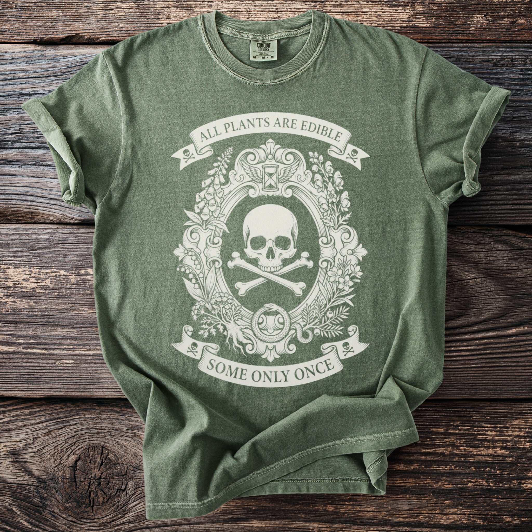 Green t-shirt with a skull and crossbones emblem and text "ALL PLANTS ARE EDIBLE SOME ONLY ONCE".