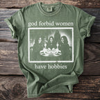 Green t-shirt with "god forbid women have hobbies" text and Ouija board image.