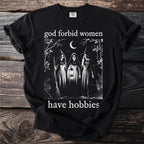 Black t-shirt with "god forbid women have hobbies" and a witch illustration.